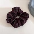 Detail eines rot-grauen karierten Haargummis mit weicher Stoffstruktur und Muster - Dunkelrot Karomuster Scrunchie