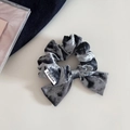 Primer plano de coletero de terciopelo gris con lazo, textura fina y etiqueta de marca blanca - Azul grisáceo