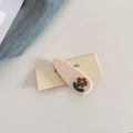 Detailed shot of cream acetate floral hair clip with stitched edges and brown flower decoration - Beige