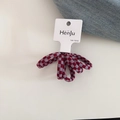 Detailopname van rood-grijze geruite haarelastiek op de originele displaykaart - Plaid Stijl