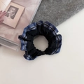 Dettaglio di scrunchie a quadri blu in tessuto elastico su una rivista vintage - Quadri Blu Notte