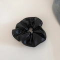 Detailed view of the glossy black leather scrunchie showing rich texture and elastic folds - Black Large