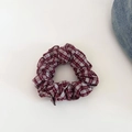 Detailed view of a red and white checkered fabric scrunchie on a white and denim surface - Wine Red Plaid