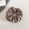 Detailed view of large pearlescent satin scrunchie in elegant dark brown coffee tone - Champagne