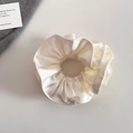 Detailed texture of pearlescent satin hair scrunchie with elegant pleats and metal charm - Rice White