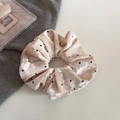 Détail de chouchou en velours à pois rose pâle avec des plis de haute qualité - Beige