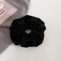 Gros plan d'un chouchou en velours noir à pois sur tricot gris avec accessoires élégants - Noir