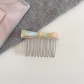 Detalle de peine para el cabello con lazo de acetato jaspeado y púas de metal - Naranja Irisado