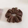 Detailed close-up of dark brown knit scrunchie with soft pleated texture and elastic design - Brown