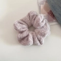 Close-up of a soft lilac knitted hair scrunchie with fluffy texture on a denim background - Light Apricot Gray