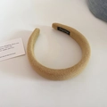 Close-up of khaki knitted padded headband showing thick fabric texture and inner brand label - Yellow