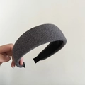 Primer plano de una diadema acolchada de punto gris con textura suave y diseño ancho - Gris claro