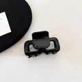 Close-up of a glossy black acetate hair claw clip with cutout design on a minimalist background - Minimalist Glossy Black