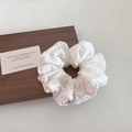 Dettaglio dell'elastico per capelli in pizzo bianco con intricati motivi all'uncinetto - Bianco