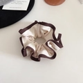 Gros plan sur le chouchou crème et marron avec bord contrasté au style rétro élégant - Beige