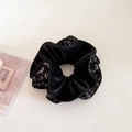 Dettaglio ravvicinato di un elastico per capelli in velluto nero con motivi floreali vintage - Nero