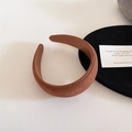 Detalle de una diadema gruesa de ante marrón con textura suave y forro interior de piel - Café