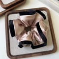 Detail view of large champagne satin scrunchie with elegant black velvet trim contrast - Champagne