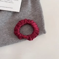 Primo piano di elastico in raso rosso vino con elegante texture plissettata e seta lucida - 1# Stile di Base