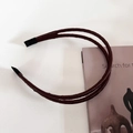 Gros plan d'un serre-tête en satin marron à double couche avec embouts de protection - Café Foncé