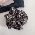 Texture détaillée du chouchou en tissu noir avec de délicats motifs floraux blancs - Noir