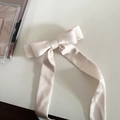 Detaillierte Textur der hellbeigen Satin-Haarschleife mit eleganten langen Bändern - 1# Cremeweiß