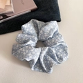 Vue détaillée d'un chouchou à fleurs bleu clair sur un bureau esthétique - 1# Bleu