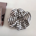 Détail d'un chouchou en tissu à rayures noires et blanches sur une surface blanche - Gris Foncé