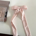 Detailansicht der rosa Satin-Schleife Haarklammer mit eleganten langen Bändern auf Weiß - Rosa