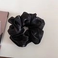 Close-up of black oversized organza scrunchie with lightweight pleated texture and sheer finish - Black