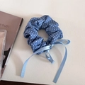 Detailansicht eines blauen gepunkteten Haargummis mit Bändern auf strukturierter Fläche - 3# Blau Weiß Punktmuster