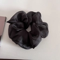 Detail of a large black organza scrunchie with soft silk luster on a white background - Black