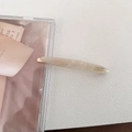 Detail of elegant beige marble acetate hair clip with golden metal base and engraving - Mermaid White