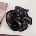 Dettaglio di elastico scrunchie nero floreale con pieghe in tulle e stile vintage romantico - Nero