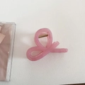 Detail of pink jelly-colored hair claw clip with twisted ribbon design and gold spring - Bow Style - Pink