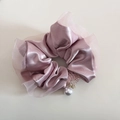 Dettaglio dello scrunchie in raso rosa con bordo in organza e pendente a perla raffinato - Rosa