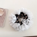 Close-up of floral fabric hair scrunchie with layered white lace embroidery detail - Black
