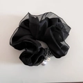 Dettaglio di elastico in raso nero con perline grigie e un ciondolo a perla bianca - Nero