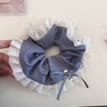 Détail d'un chouchou plissé en tissu bleu avec volants blancs et petit noeud - Bleu