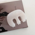 Detail of a large cream jelly hair claw clip with a glossy finish on a magazine page - Fat M Style - Beige