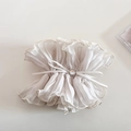 Detail eines cremeweißen Organza-Scrunchies mit Rüschen und Kristall-Schleifenakzenten - Beige Tailliertes Design