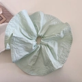 Detalle de un coletero gigante verde menta de tela con textura plisada suave y costuras finas - Verde Leche de Lima