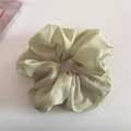 Gros plan sur chouchou en organza vert clair pailleté avec texture plissée douce - Vert fruit