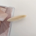 Macro view of the creamy yellow oval acetate hair clip with smooth resin finish - 2# Milk Apricot Stripe