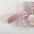 Detail of light pink acetate marble patterned long hair clip with gold lettering accent - Pink Stripe