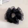 Detailaufnahme von schwarzem Organza-Haargummi mit geraffter Netzstruktur und Volumen - Schwarz