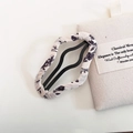 Detail of floral fabric wrapped wavy hair clip with black floral pattern on white background - Beige Floral Cloud Wave