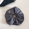 Détail du chouchou à rayures bleues avec bord en dentelle, bouton déco et label Happiness - Style Étiquette Gris Foncé
