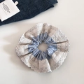 Détail d'un chouchou en tissu à rayures bleues avec bordure en dentelle crème sur blanc - Style Dentelle à Rayures Verticales Bleu Clair