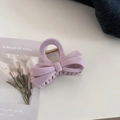 Detail view of a pale purple bow hair claw clip with a gold metal spring mechanism - Ribbon Bowknot / Taro Pink